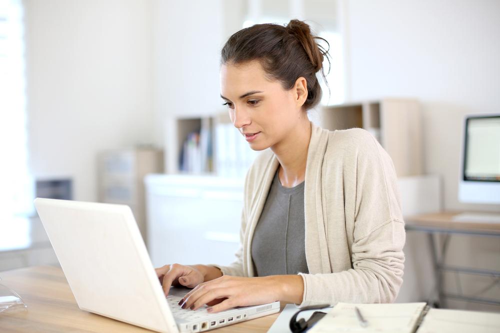 Attractive woman working in office on laptop - mudahnya komunikasi dengan pelanggan lewat multiplechat