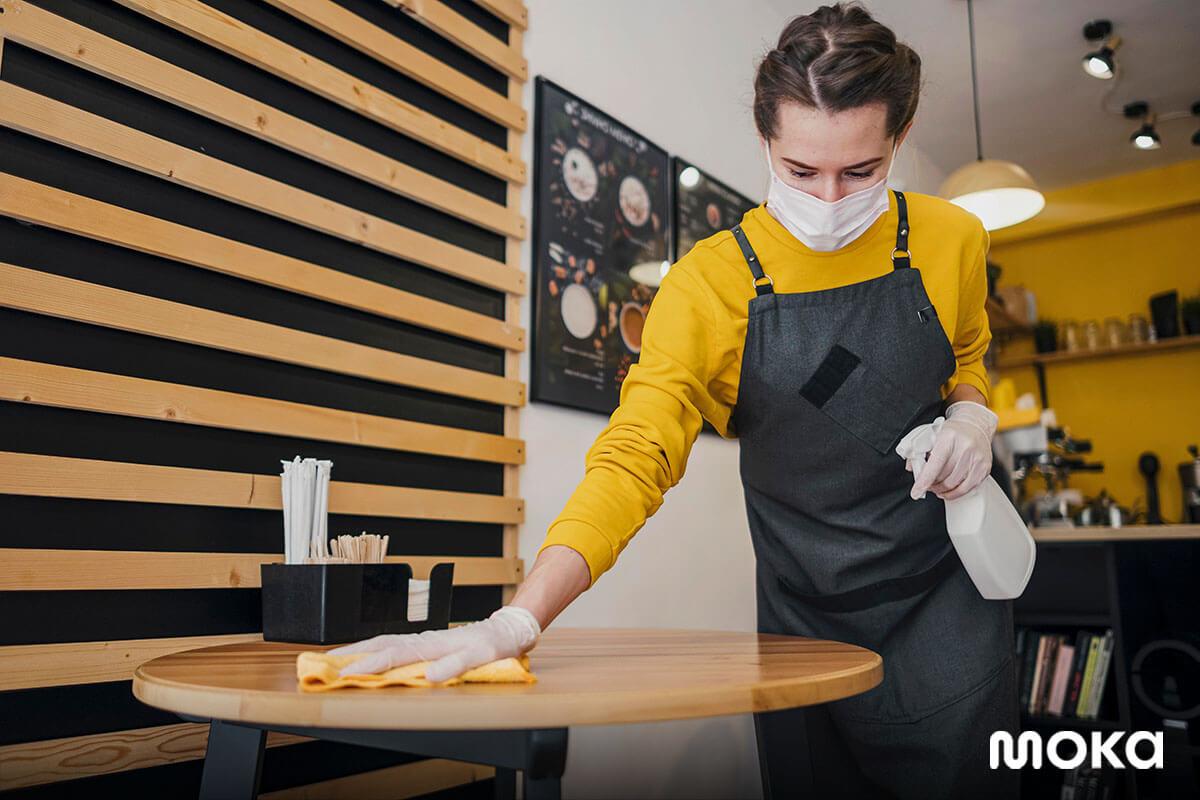 barista membersihkan meja di kedai kopi sebagai salah satu strategi marketing terbaik dalam merebut pelanggan