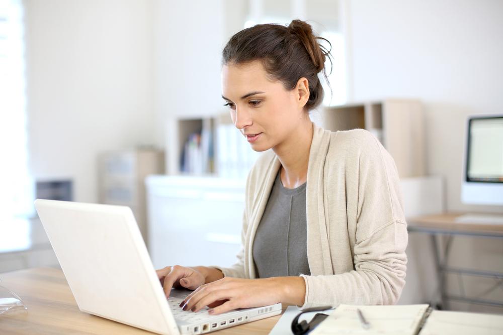 Attractive woman working in office on laptop - freelance writer - Bisnis Rumahan Modal Kecil