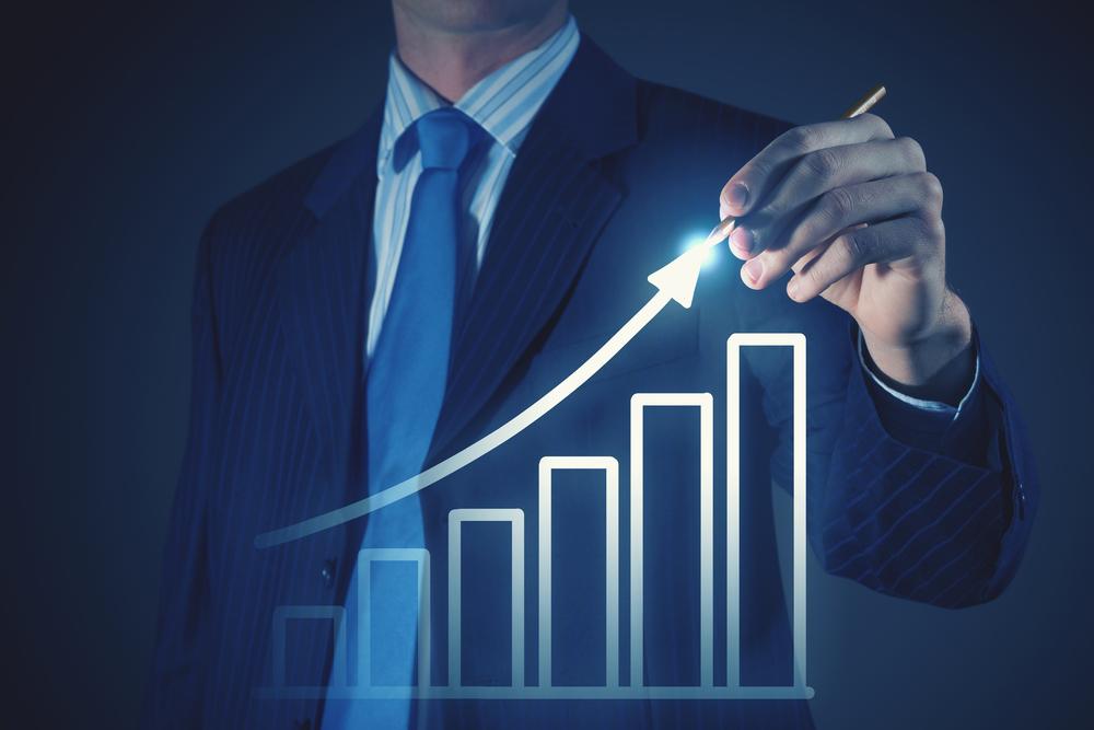 Chest view of businessman drawing with pencil increasing graph