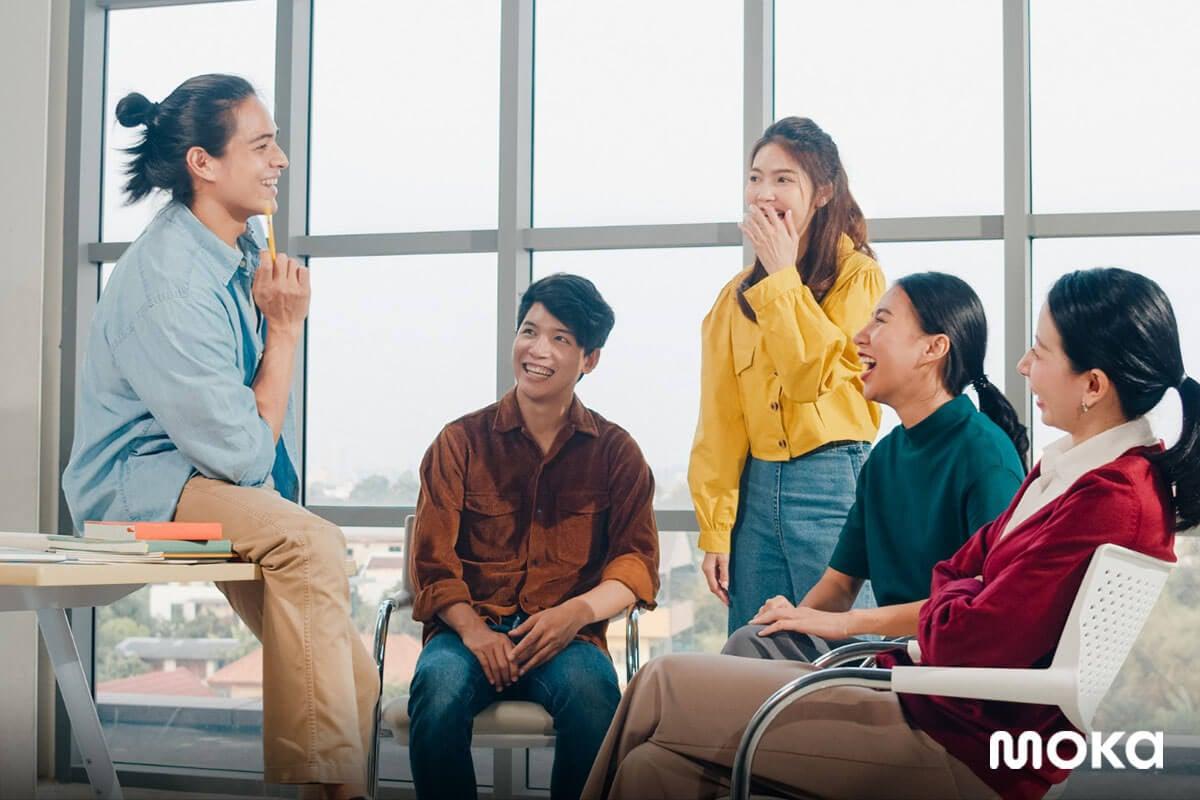 karyawan muda sedang brainstorming atau meeting - generasi milenial - tampak senang dengan kantor