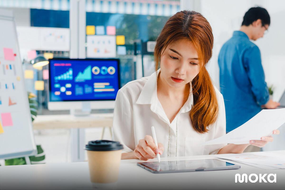 pebisnis wanita sedang mengecek laporan penjualan usahanya (1)