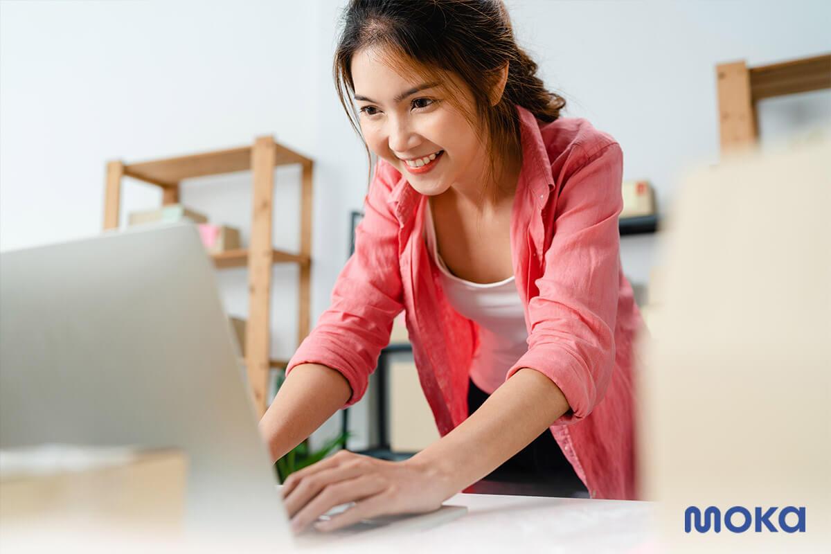 seorang pemilik usaha sedang mencatat transaksi pelanggan